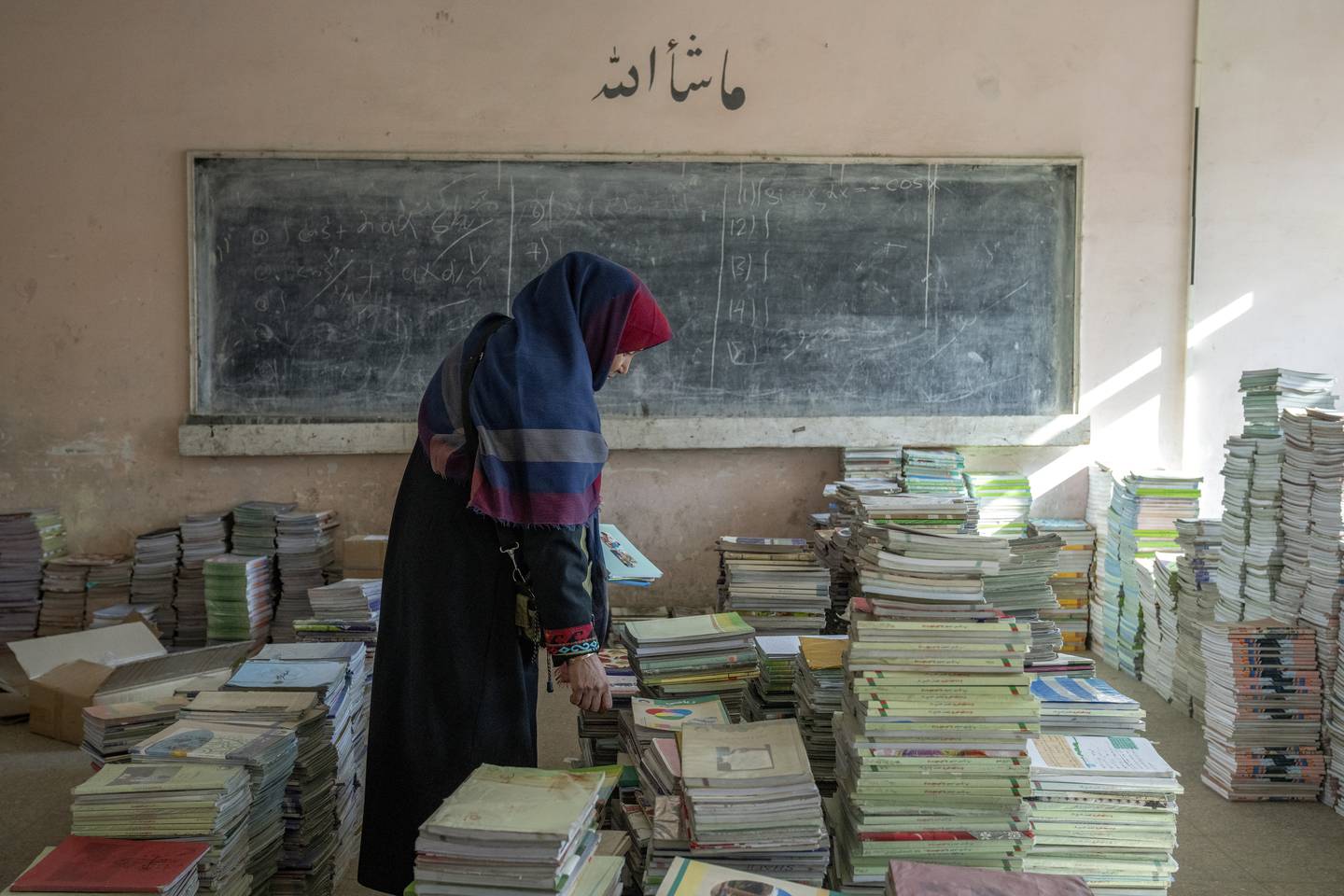 Den afghanske skolelæreren Amanah Nashenas (45) samler bøker på en skole i Kabul. Taliban, som har makten i landet, nektet nylig kvinner å ta delta i utdanningen på landets universiteter. Nå nektes også kvinnelige bistandsarbeidere å jobbe. Foto: Ebrahim Noroozi / AP / NTB