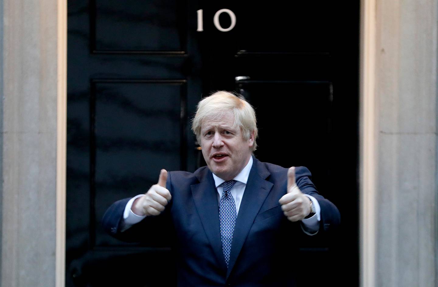 Britain's Prime Minister Boris Johnson shows thumbs up before he applauds on the doorstep of 10 Downing Street in London during the weekly "Clap for our Carers" Thursday, April 30, 2020. The COVID-19 coronavirus pandemic has prompted a public display of appreciation for care workers. The applause takes place across Britain every Thursday at 8pm local time to show appreciation for healthcare workers, emergency services, armed services, delivery drivers, shop workers, teachers, waste collectors, manufacturers, postal workers, cleaners, vets, engineers and all those helping people with coronavirus and keeping the country functioning while most people stay at home in the lockdown. (AP Photo/Kirsty Wigglesworth)