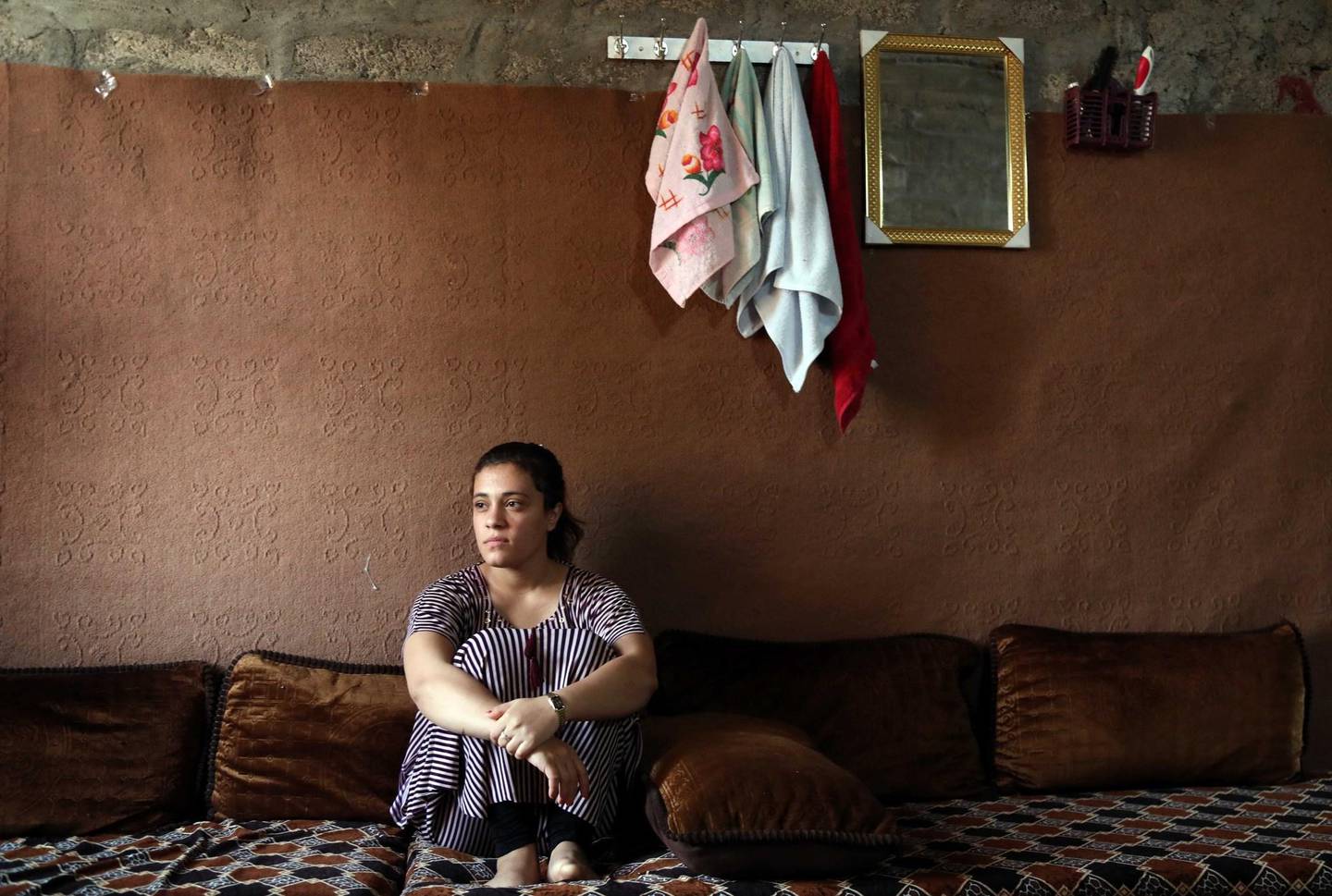 Iraq's Yazidi Jihan Qassem, 18, pauses as she talks to a AFP reporter at a makeshift house in an area housing many displaced people on the outskirts of the northwestern Iraqi town of Baadre on June 25, 2019. - Three children fathered by her Islamic State group husband. Three siblings missing since the Islamic State group ravaged her village in 2014. At 18, Yazidi survivor Jihan abandoned the former to honour the latter. The same gutwrenching dilemma has been faced by dozens of Yazidi women and girls forced to carry jihadists' children after IS abducted them from their ancestral Iraqi home of Sinjar in 2014. (Photo by SAFIN HAMED / AFP)