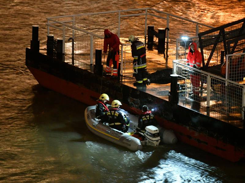 Responders sit in a rubber dinghy preparing for the search of victims next to a landing dock after a tourist boat crashed with another ship late Wednesday, May 29, 2019. The boat capsized and sunk in the Danube River Wednesday evening, May 29, 2019, in Budapest, with dozens of people on board, including passengers and crew, Hungarian media reported. (Zsolt Szigetvary/MTI via AP)