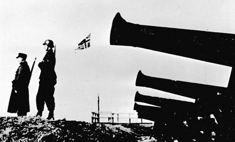 Agdenes festning er tatt av tyske invasjonsstyrker. Det norske flagget og hakekorsflagget vaier, og en norsk og en tysk soldat står side om side. FOTO: NTB SCANPIX