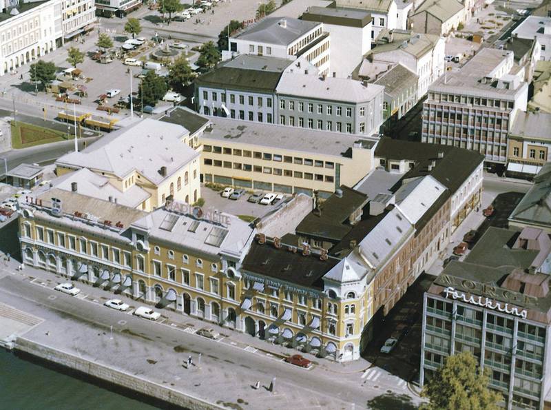 1970: Drammens Tidende Buskeruds Blad hadde lenge sine redaksjonslokaler i bygget i Nedre Strandgate. På taket skimtes bokstavene DTBB. FOTO: DRAMMEN BYARKIV