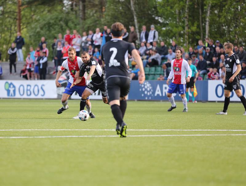 Stian Sortevik utfordrer Strømmen-spillere, målscorer Christoffer Dahl til høyre.