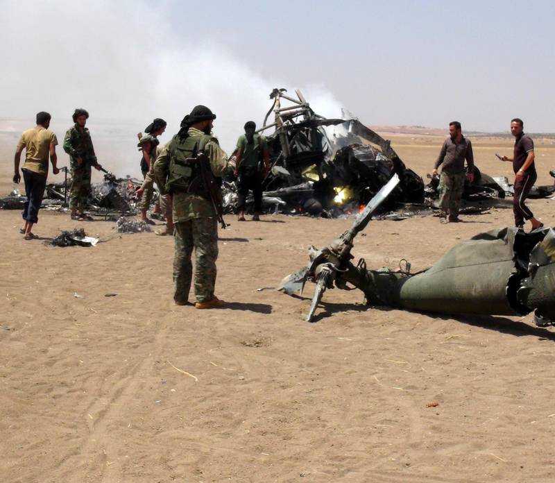 Syriske opprørere ved vraket av et russisk Mi-8 militær­helikopter etter at det var skutt ned nord i Syria i august. 
