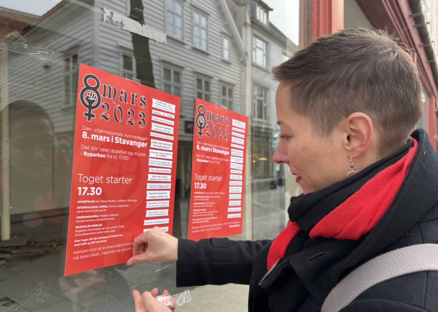 Sara Nustad Mauland henger opp plakater med programmet for 8. Mars