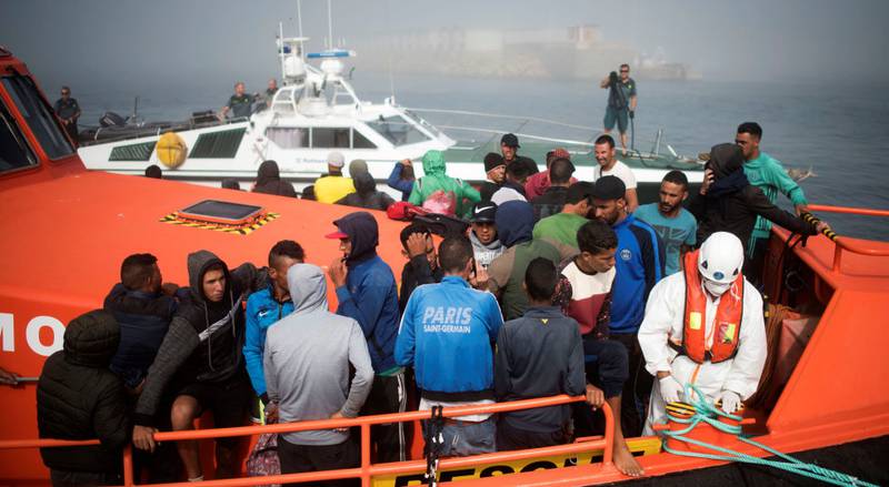 En gruppe migranter går om bord i en redningsbåt sør for Spania. 