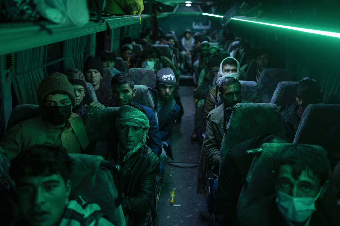 Afghanske menn sitter om bord en buss i Herat, på vei mot Nimrooz ved grensa til Iran.