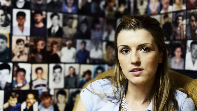 Advidja i hovedkontoret for organisasjonen Mothers of Srebrenica. Hun er en av tolv deltakere i Brusselmans' prosjekt om unge som mistet familiemedlemmer i massakren. Veggen er dekket med bilder av ofrene. FOTO: Sindre Brusselmans