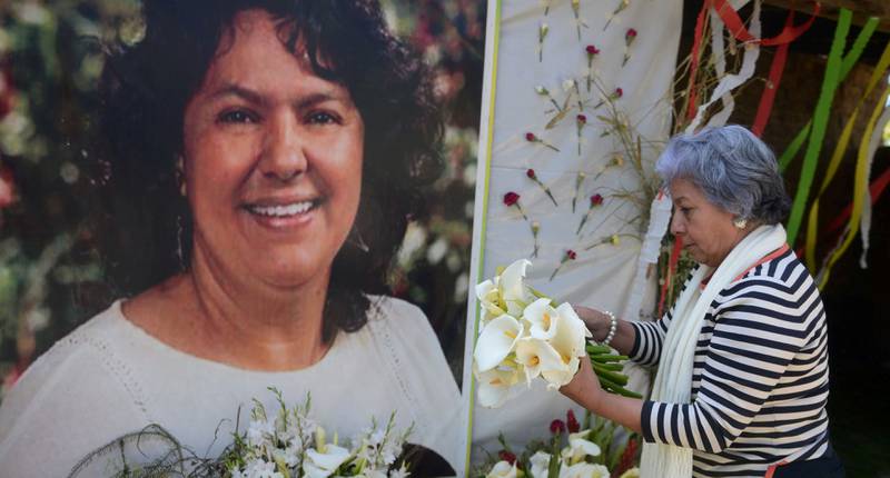 Den honduranske miljøaktivisten og menneskerettighetsforkjemperen Berta Cáceres ble et symbol på kampen mange urfolk og lokalbefolkning kjemper i konflikter om rett til eget land i Latin-Amerika. Her legger en kvinne blomster ved et minnealter over Cáceres.