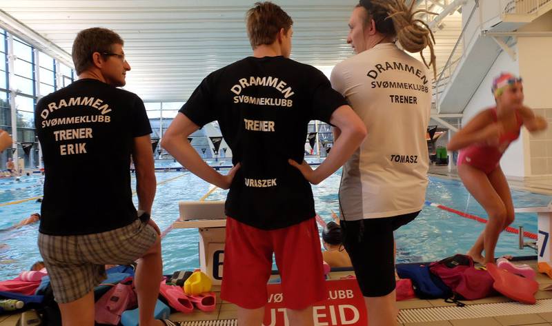 På lag: Den polske stjernen har fått egen T-skjorte som «gjestetrener» i Drammen Svømmeklubb. Til høyre den faste treneren Tomas Sobek, som selv har svømt på høyt nivå i USA.