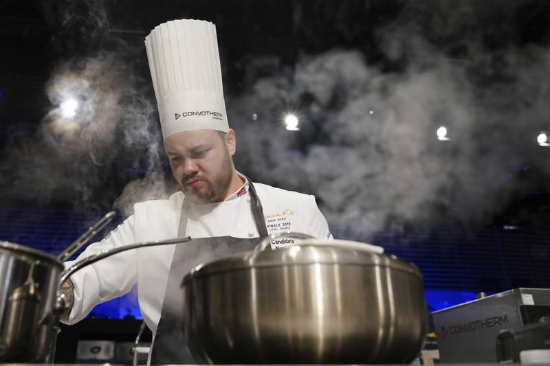 Christian Andre Pettersen, of Norway, prepares food during the final of the "Bocuse d'Or" (Golden Bocuse) trophy, in Lyon, central France, Tuesday, Jan. 29, 2019. The contest, a sort of world cup of cuisine, was started in 1987 by Lyon chef Paul Bocuse to reward young international culinary talents. (AP Photo/Laurent Cipriani)