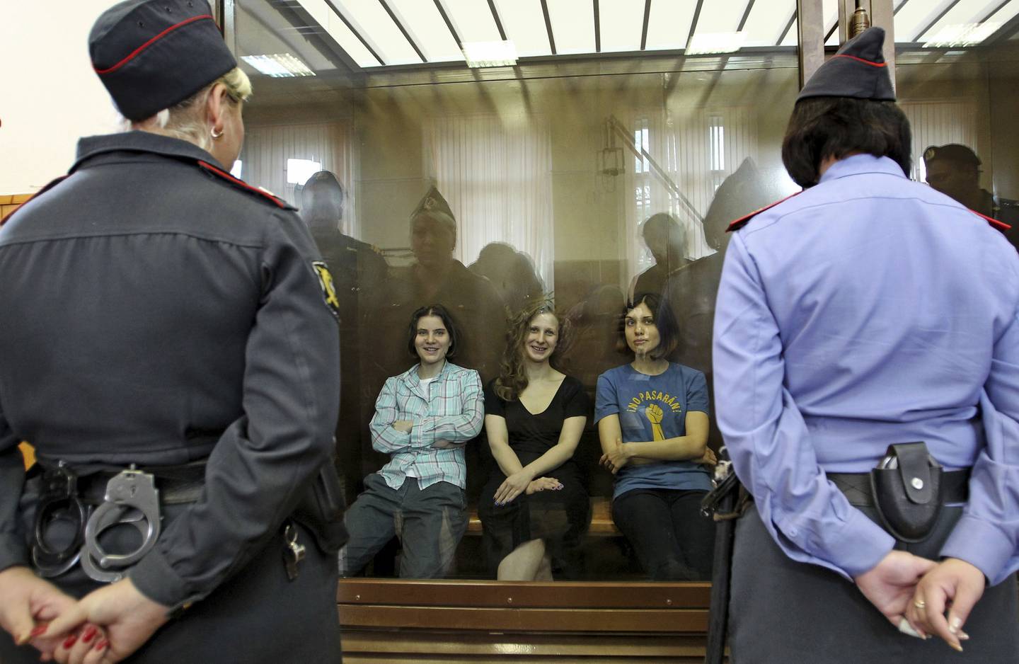 F.v. Jekaterina Samutsevitsj, Marija «Masha» Aljokhina og Nadezjda Tolokonnikova, alle tre Pussy Riot-medlemmer, fotografert i et glassbur i rettssalen i Moskva den 17. august 2012. Alle tre ble dømt for «pøbelvirksomhet», selv om to av dem er mødre, men Samutsevitsj fikk dommen betinget.