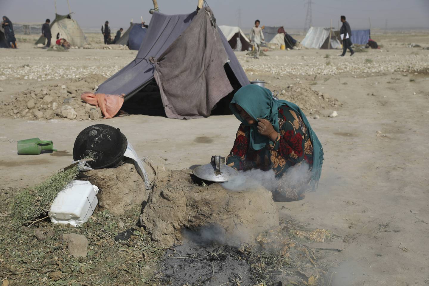 En kvinne lager te av tornekvister i en teltleir i byen Mazar-e-Sharif i Nord-Afghanistan.