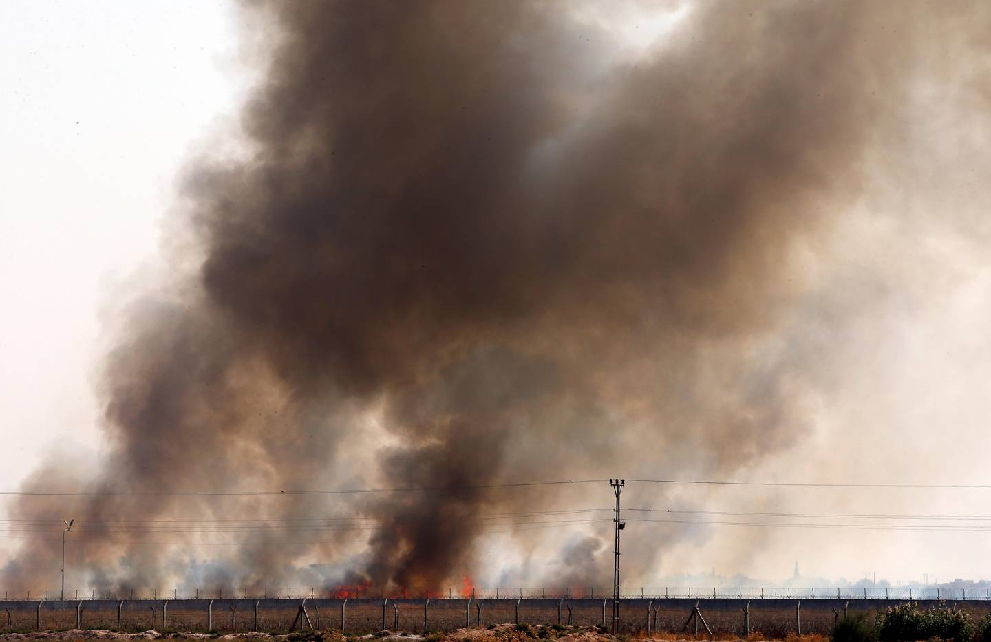 In this photo taken from the Turkish side of the border between Turkey and Syria, in Akcakale, Sanliurfa province, southeastern Turkey, smoke billows from fires on targets in Tel Abyad, Syria, caused by bombardment by Turkish forces, Sunday, Oct. 13, 2019. The United Nations says at least 130,000 people have been displaced by the fighting in northeastern Syria with many more likely on the move as a Turkish offensive in the area enters its fifth day. (AP Photo/Lefteris Pitarakis)