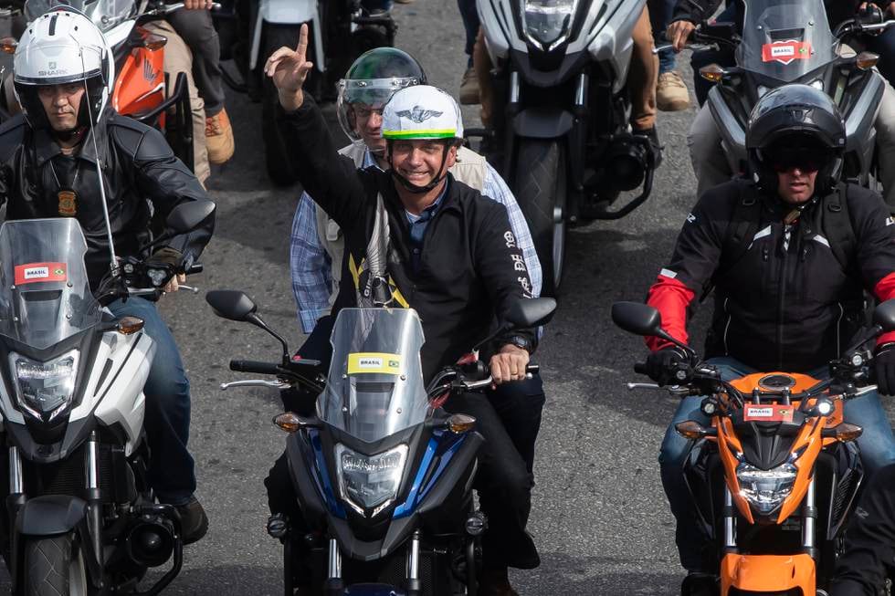 Jair Bolsonaro. -med hjelm, men uten munnbind – ledet an i en MC-parade gjennom Rios gater søndag. Foto: Bruna Prado / AP / NTB 