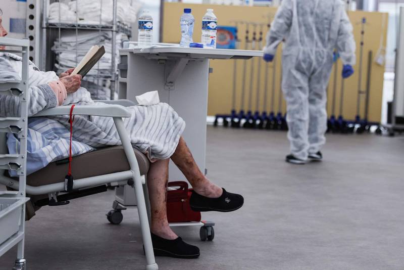 A patient reads a book in an auxiliary unit built at Verviers hospital to welcome patients infected by Covid-19 (novel coronavirus) on November 9, 2020. - Belgium is in a second lockdown as the hospitalisations of  patients suffering from the novel coronavirus, Covid-19, reach record highs. (Photo by Kenzo TRIBOUILLARD / AFP)