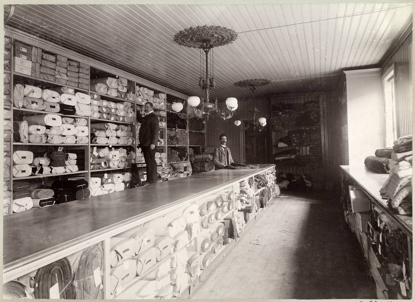 Engroslager for ruller med ulike egenproduuserte stoffer i Gunerius Pettersen magasin i 1902.