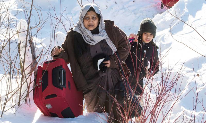 En asylsøker og datteren hennes krysser grensen fra USA til Canada 17. mars i år. Stadig flere asylsøkere som først ankom USA har bestemt seg for å flykte på ny i frykt for Donald Trumps nye flyktningpolitikk.