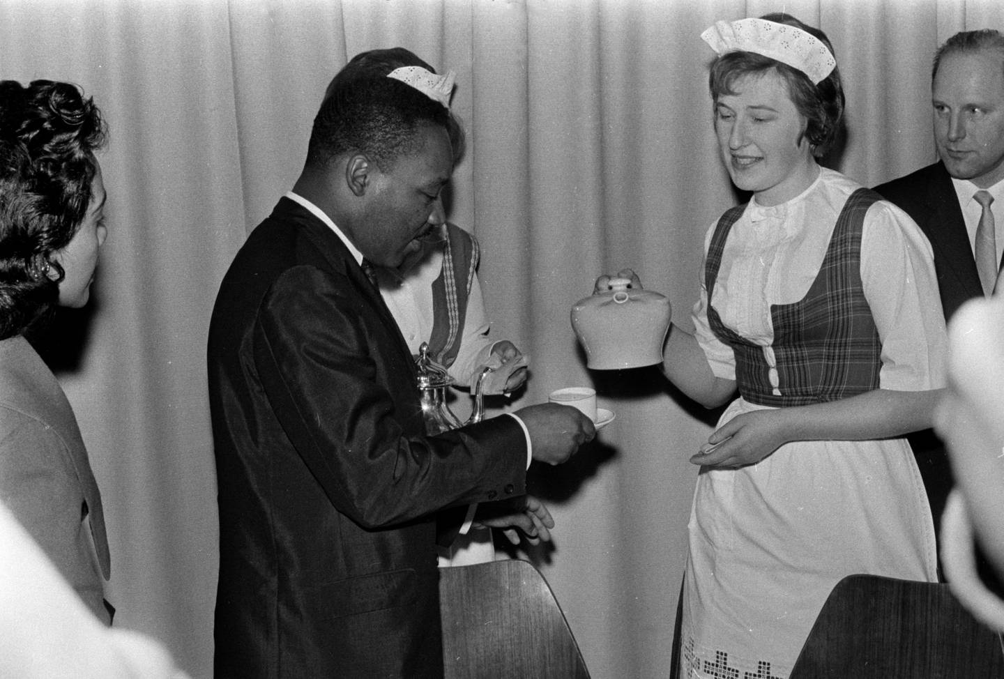 King får te av dame i bunad: Martin Luther King var selv tidligere baptistprest, og ble mottatt med varme og te i en baptistmenighet i Oslo. Foto: Arbeiderbevegelsens arkiv