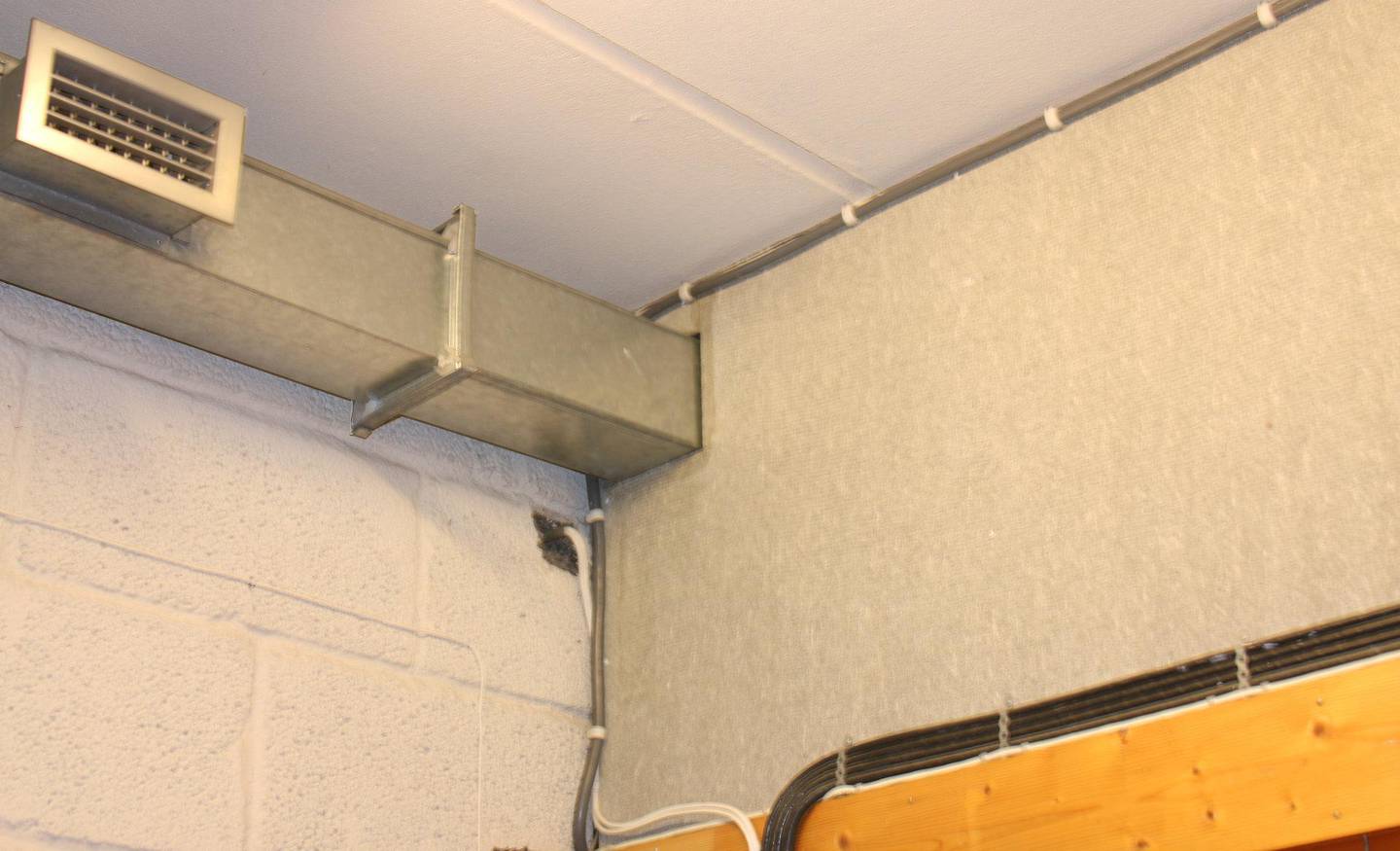 Overalt i Bøler IFs klubbhus er det slike grå asbestplater. Her er ventilasjonsanlegget ført gjennom en plate.