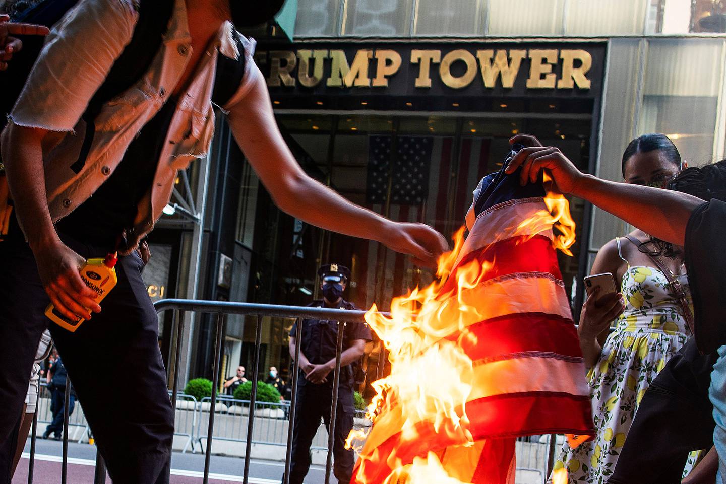 Protesters burn American flags during a protest in front of Trump Tower, Saturday, July 4, 2020, in New York. (AP Photo/Eduardo Munoz Alvarez)