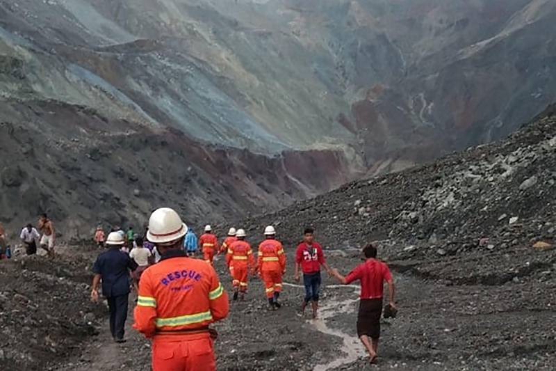 This handout from the Myanmar Fire Services Department taken and released on July 2, 2020 shows rescuers attempting to locate survivors after a landslide at a jade mine in Hpakant, Kachin state. - The bodies of at least 50 jade miners were pulled from the mud on July 2 after a landslide in northern Myanmar, fire services said, as monsoon rains worsen already deadly conditions. (Photo by Handout / MYANMAR FIRE SERVICES DEPARTMENT / AFP) / -----EDITORS NOTE --- RESTRICTED TO EDITORIAL USE - MANDATORY CREDIT "AFP PHOTO / MYANMAR FIRE SERVICES DEPARTMENT " - NO MARKETING - NO ADVERTISING CAMPAIGNS - DISTRIBUTED AS A SERVICE TO CLIENTS