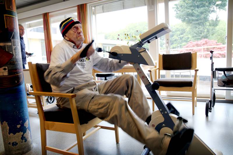 Alf Oskar Olsen (103) er den eldste deltakeren i sykkel-VM, og bærer ledertrøyen på Domkirkens sykehjem. Deltakerne sykler på en spesiallaget ergometersykkel med hjelpemotor som er koblet til filmopptak av sykkelruter i nærområdet. FOTO: TONE HELENE OSKARSEN