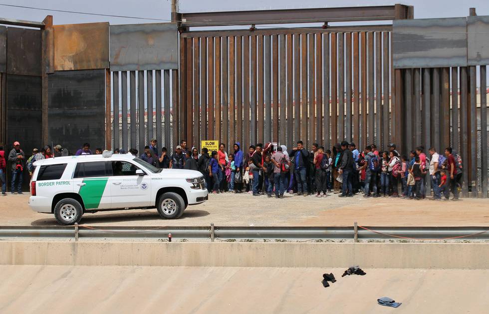 (FILES) In this file photo taken on May 7, 2019, Central American migrants are detained by US Customs and Border Patrol agents at the border wall in Ciudad Juarez, Chihuahua state, Mexico. - US President Donald Trump on January 9, 2020, welcomed a court decision that allows $3.6 billion in military funds to be used to build his signature wall on the US-Mexico border. "Entire Wall is under construction or getting ready to start!" the president tweeted following the ruling by the Fifth US Circuit Court of Appeals. (Photo by HERIKA MARTINEZ / AFP)