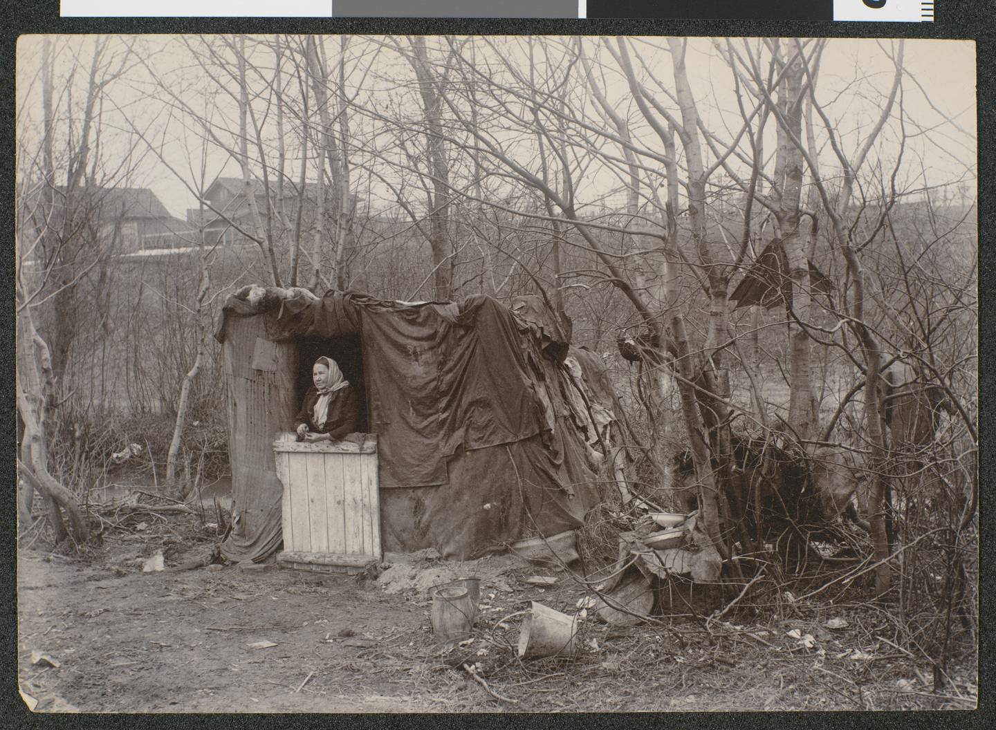 Familiebolig på Frøen i Vestre Aker april 1897 (!). En kvinne stående i døråpningen til skuret som er ett av flere lignende boliger i området.