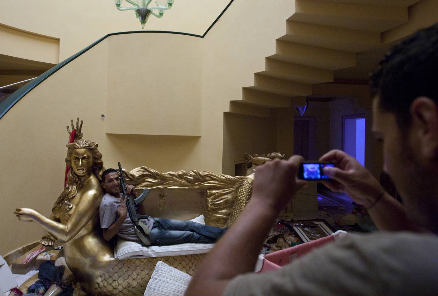 Opprørere inne i huset til Muammar Gaddafis datter Aisha. Havfrue-sofaen har Aisha Gaddafis ansikt.