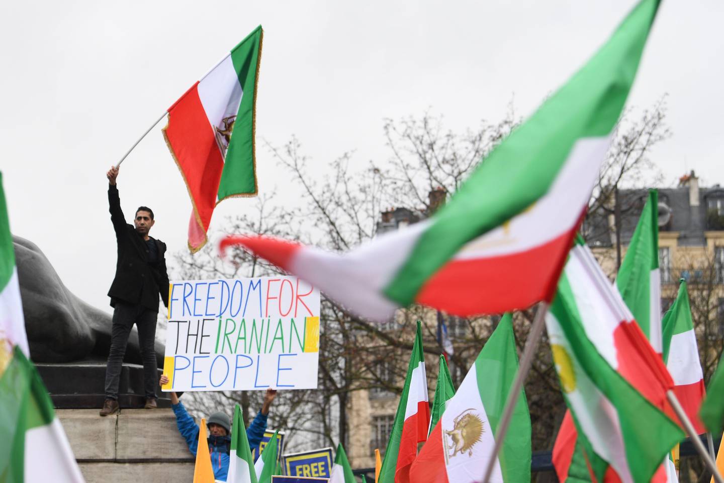 People wave former Iranian flags during a demonstration of the exiled Iranian opposition to protest against the celebration in Iran of the 40th anniversary of the Islamic Revolution, on February 8, 2019 in Paris. (Photo by Alain JOCARD / AFP)