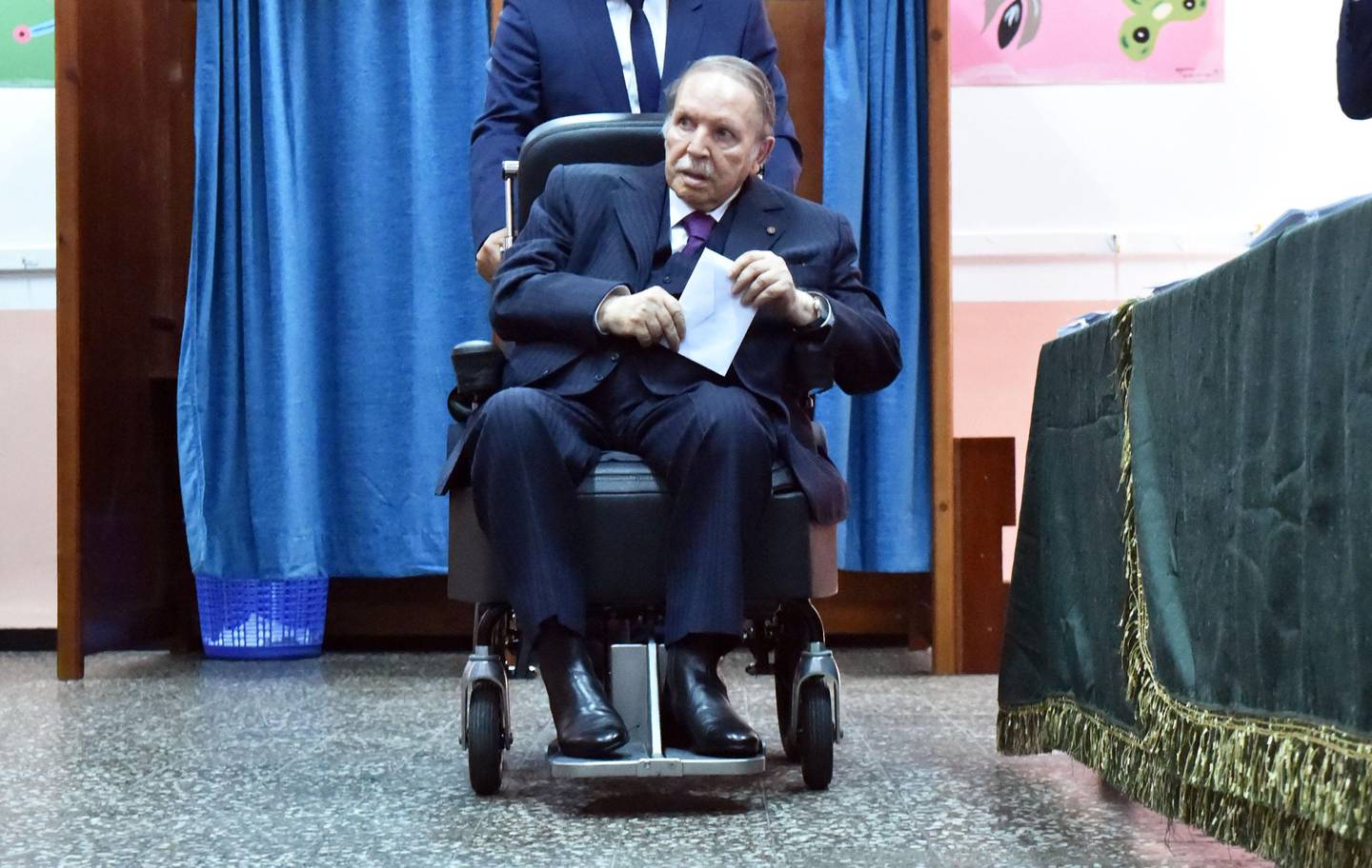 Algerian President Abdelaziz Bouteflika is seen on a wheelchair as he casts his vote at a polling station in Algiers on May 4, 2017 during parliamentary elections.
Algerians voted for a new parliament amid soaring unemployment and a deep financial crisis caused by a collapse in oil revenues. / AFP PHOTO / RYAD KRAMDI
