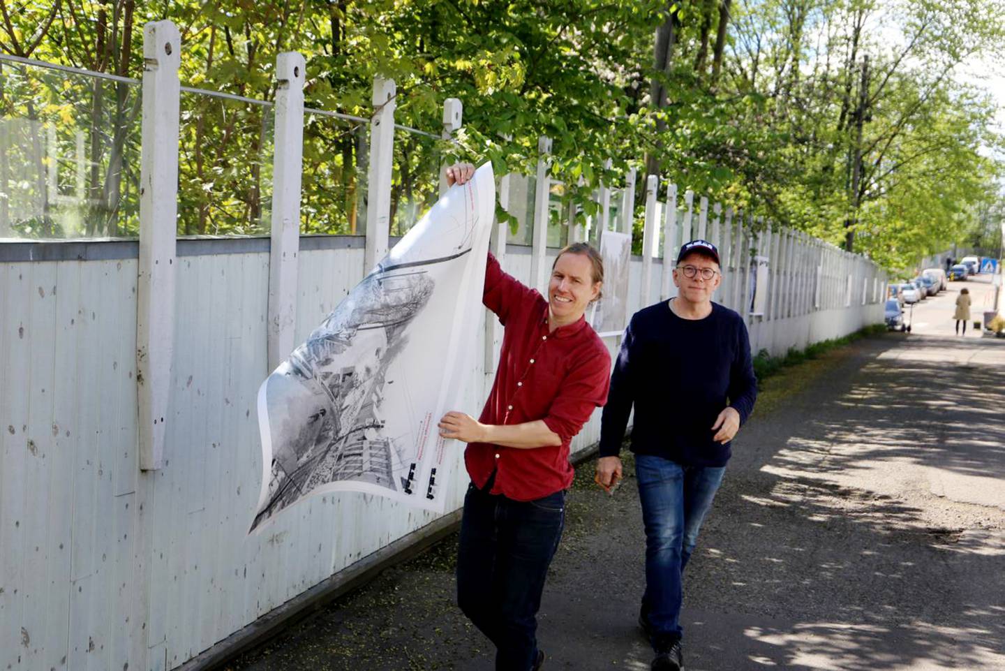 Hylla-beboer Gjermund Granlund og Even Haugseth i Vålerenga historielag henger opp bilder til en fotoutstilling om Hyllas historie.