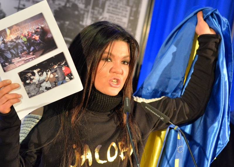 Brukes politisk: Ukrainske Ruslana Lyzhychko som vant i 2004 holder opp bilder fra demonstrasjoner mot myndighetene i 2014. 