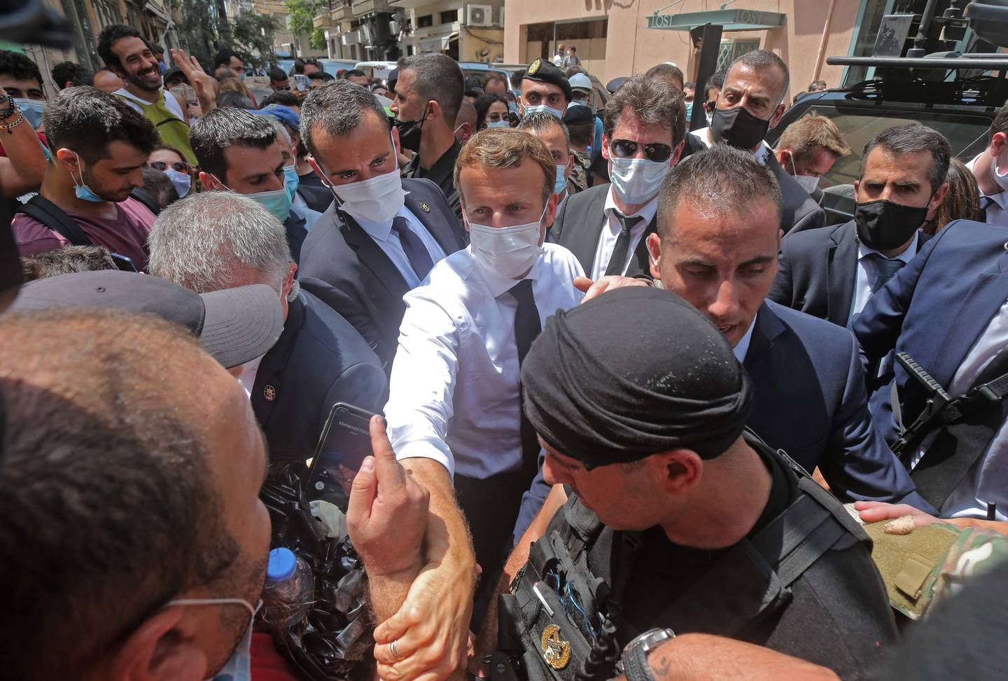 French President Emmanuel Macron greets people as he visits the Gemmayzeh neighborhood which has suffered extensive damage due to a massive explosion in the Lebanese capital, on August, 6. 2020. - French President Emmanuel Macron visited shell-shocked Beirut, pledging support and urging change after a massive explosion devastated the Lebanese capital in a disaster that has sparked grief and fury. (Photo by - / AFP)