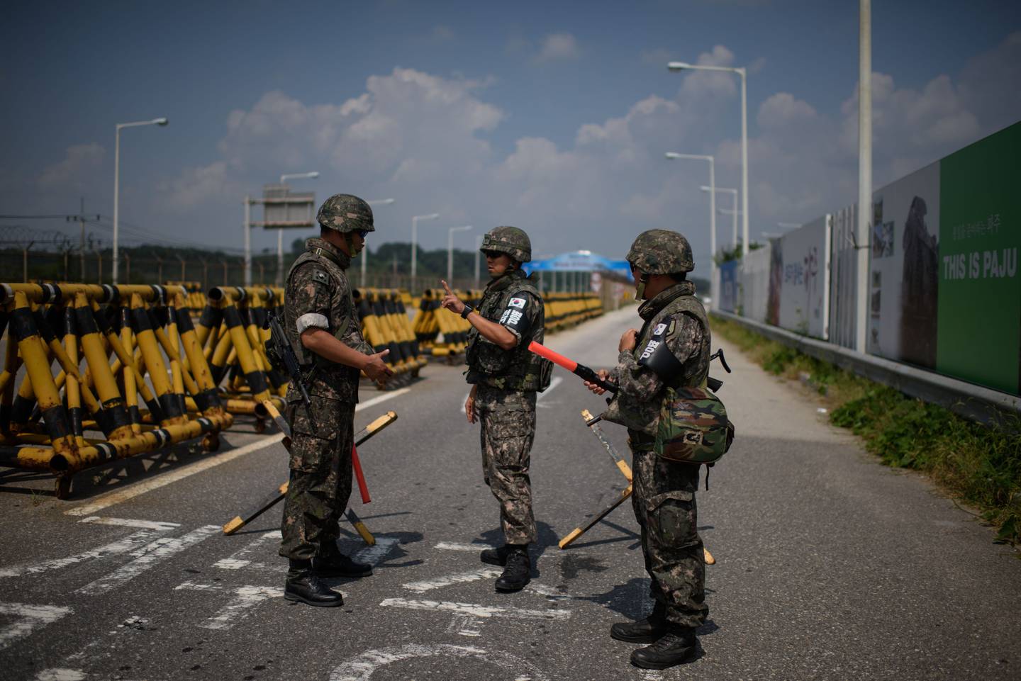 South Korean soldiers stand at the Unification Bridge leading to North Korea near the border village of Yeoncheon in the Demilitarized Zone (DMZ) on August 22, 2015. South Korean troops stood at maximum alert on August 22, hours before the expiry of a North Korean ultimatum for Seoul to halt loudspeaker propaganda broadcasts across the border or face military action.       AFP PHOTO / Ed Jones