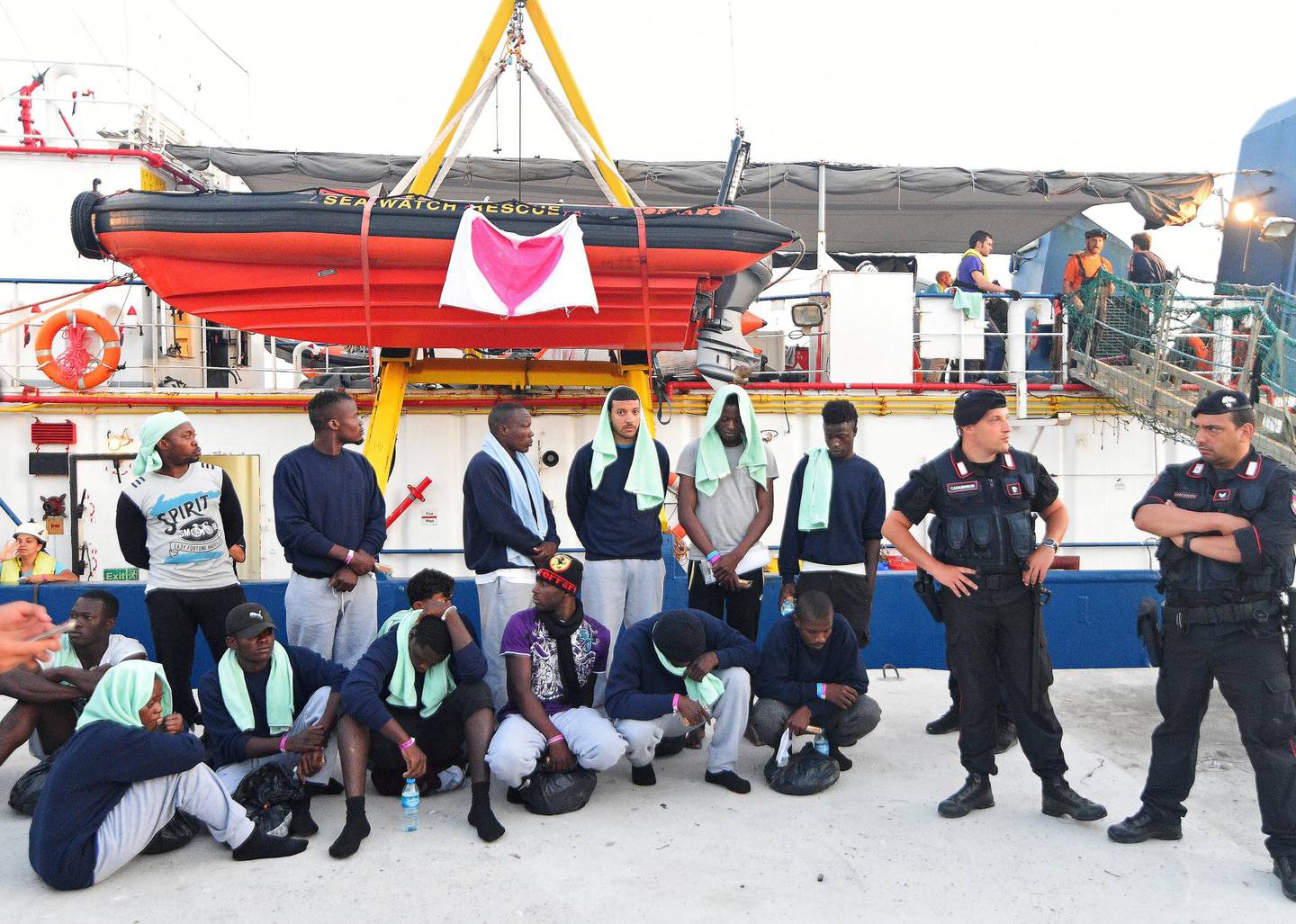 Flyktninger om bord på «Sea-Watch 3» bevoktet av italiensk politi etter at kaptein Rackete ble arrestert og skipet tatt i forvaring. FOTO: GUGLIELMO MANGIAPANE/REUTERS/NTB SCANPIX