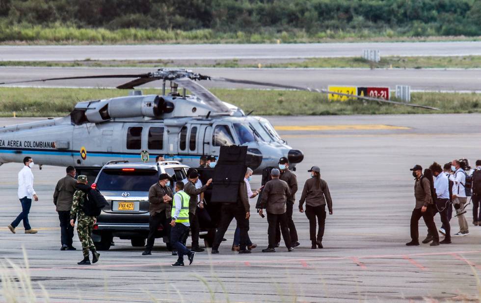 Colombias President Ivan Duque omringet av sikkerhetsvakter etter helikopteret ble angrepet