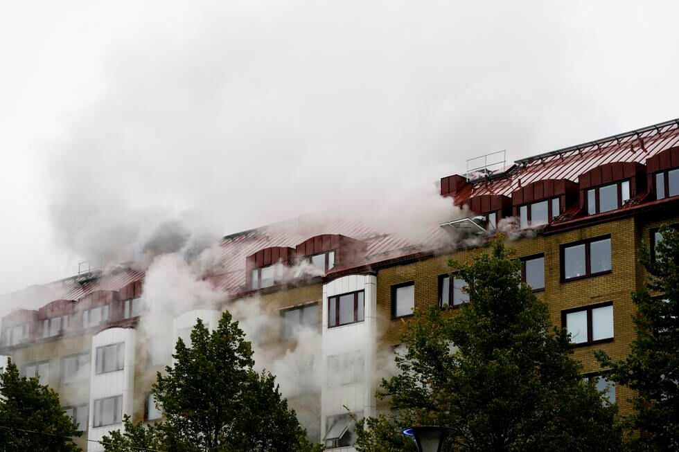 Røyken velter fortsatt ut av bygården i dagslys.
Foto: BJØRN LARSSON ROSVALL/TT / NTB
