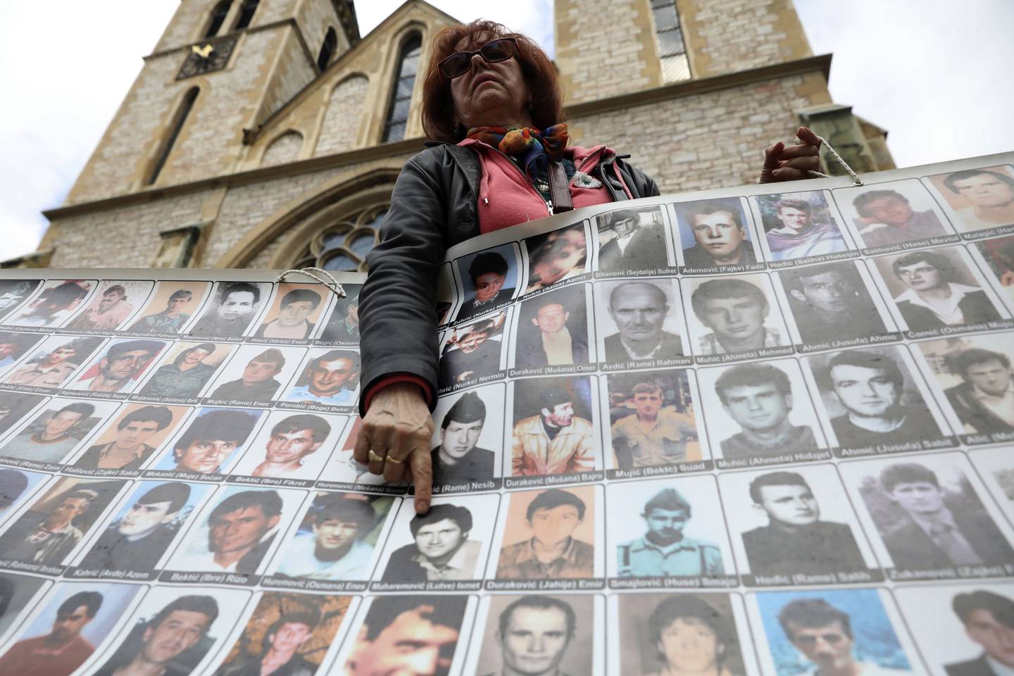 En bosnisk-muslimsk kvinne holder opp bilder av ofre for Srebrenica-massakren under en markering i Sarajevo 11. april i år.