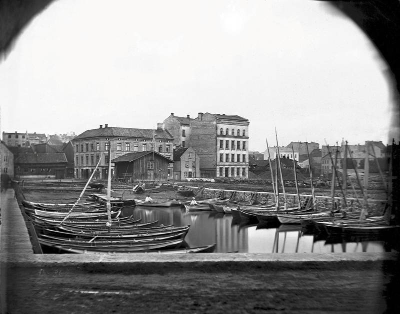 «Baadforeningen i Pipervigen» hadde tilhold i enden av «Langbryggen» i Pipervika. Bildet er fra 1860-tallet. I bakgrunnen sees skuret hvor medlemmene kunne oppbevare årer og annet utstyr, samt de første gårda i Sjøgata.
