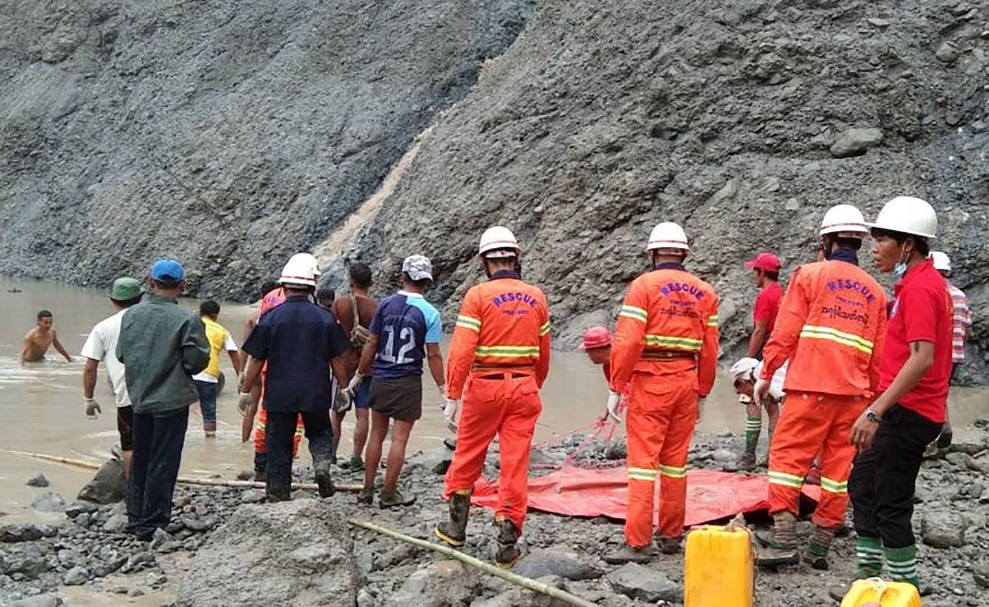 This handout from the Myanmar Fire Services Department taken and released on July 2, 2020 shows rescuers attempting to locate survivors after a landslide at a jade mine in Hpakant, Kachin state. - The bodies of at least 50 jade miners were pulled from the mud on July 2 after a landslide in northern Myanmar, fire services said, as monsoon rains worsen already deadly conditions. (Photo by Handout / MYANMAR FIRE SERVICES DEPARTMENT / AFP) / -----EDITORS NOTE --- RESTRICTED TO EDITORIAL USE - MANDATORY CREDIT "AFP PHOTO / MYANMAR FIRE SERVICES DEPARTMENT " - NO MARKETING - NO ADVERTISING CAMPAIGNS - DISTRIBUTED AS A SERVICE TO CLIENTS