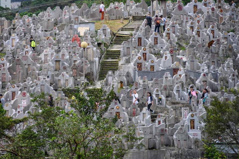 People visit the graves of relatives during the Chung Yeung Festival, or Tomb Sweeping Day, at a cemetery in Hong Kong on October 17, 2018. - The Chung Yeung Festival is a day to respect and remember family ancestors, in a ritual followed in the territory amongst the Chinese community. (Photo by Anthony WALLACE / AFP)