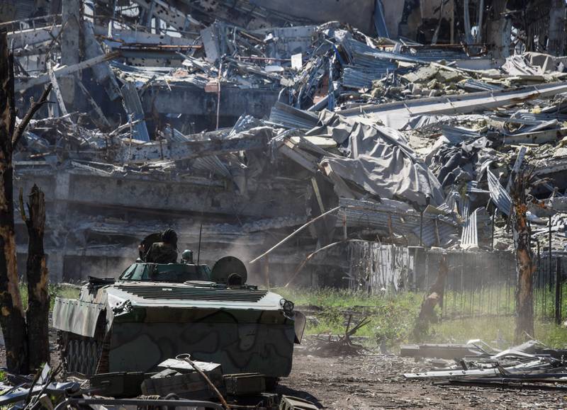 Et russisk-støttet pansret kjøretøy ved en utbombede flyplassen i Donetsk, øst i Ukraina tirsdag. FOTO: MSTYSLAV CHERNOV/NTB SCANPIX