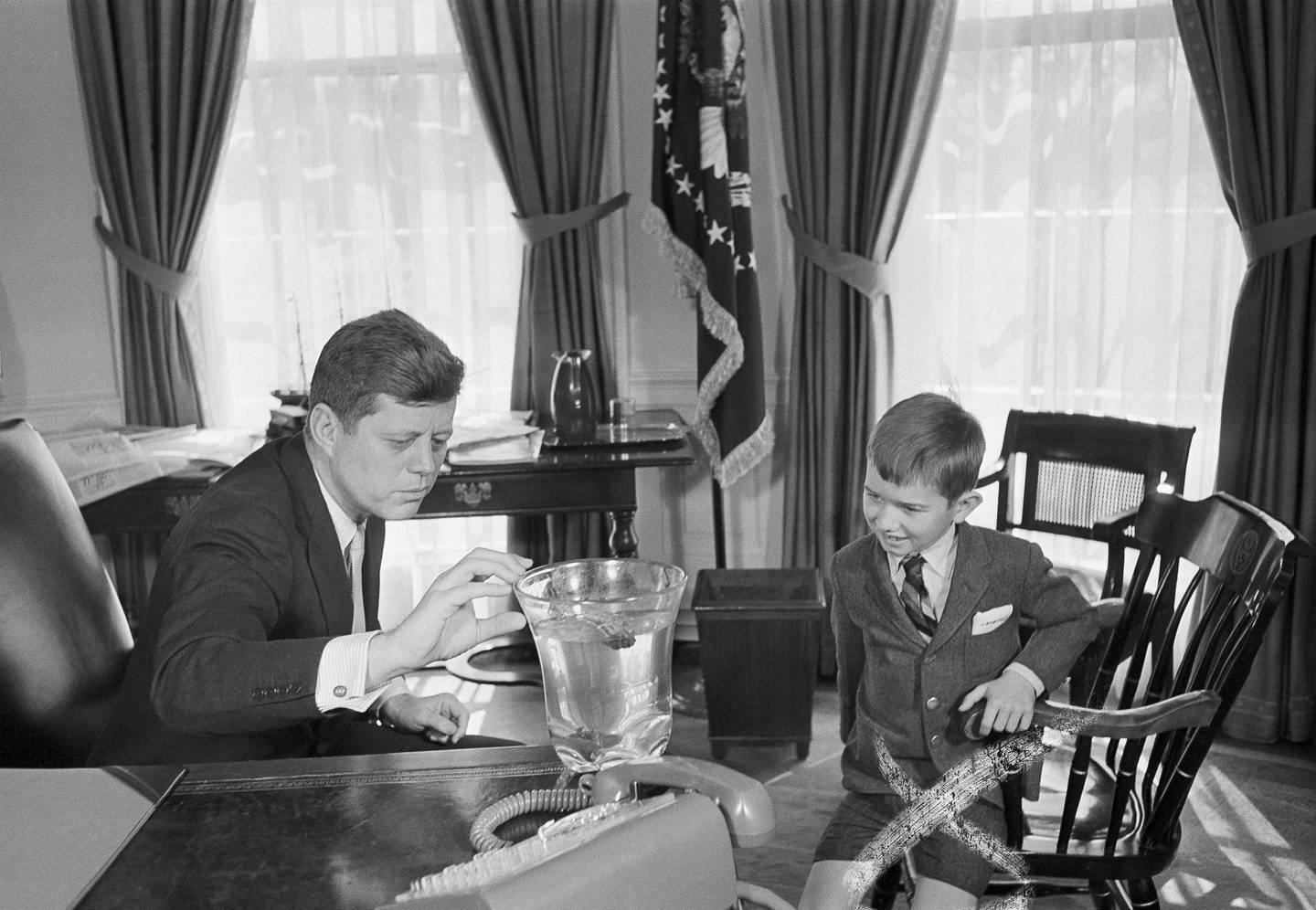 Robert Kennedy, Jr. 7, lifts a salamander named Shadrach from a vase in Uncle John F. Kennedy's presidential office March 11, 1961. Bobby who is the son of the Attorney General, showed up at the White House to give the reptile to the President, after first obtaining an official appointment. (AP Photo)