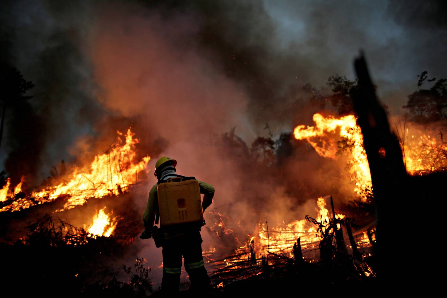 FILE PHOTO: A Brazilian Institute for the Environment and Renewable Natural Resources (IBAMA) fire brigade member attempts to control a fire in a tract of the Amazon jungle in Apui, Amazonas State, Brazil, August 11, 2020. REUTERS/Ueslei Marcelino/File Photo