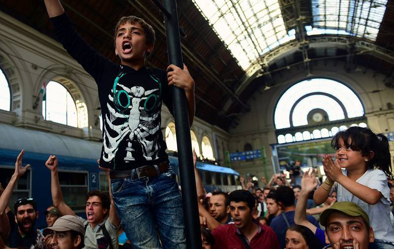 Flyktninger protesterer på togstasjonen Keleti i Budapest i går. Ungarske myndigheter stengte stasjonen etter at hundrevis av flyktninger forsøkte å komme seg om bord tog til Østerrike og Tyskland. FOTO: ATTILA KISBENEDEK/NTB SCANPIX