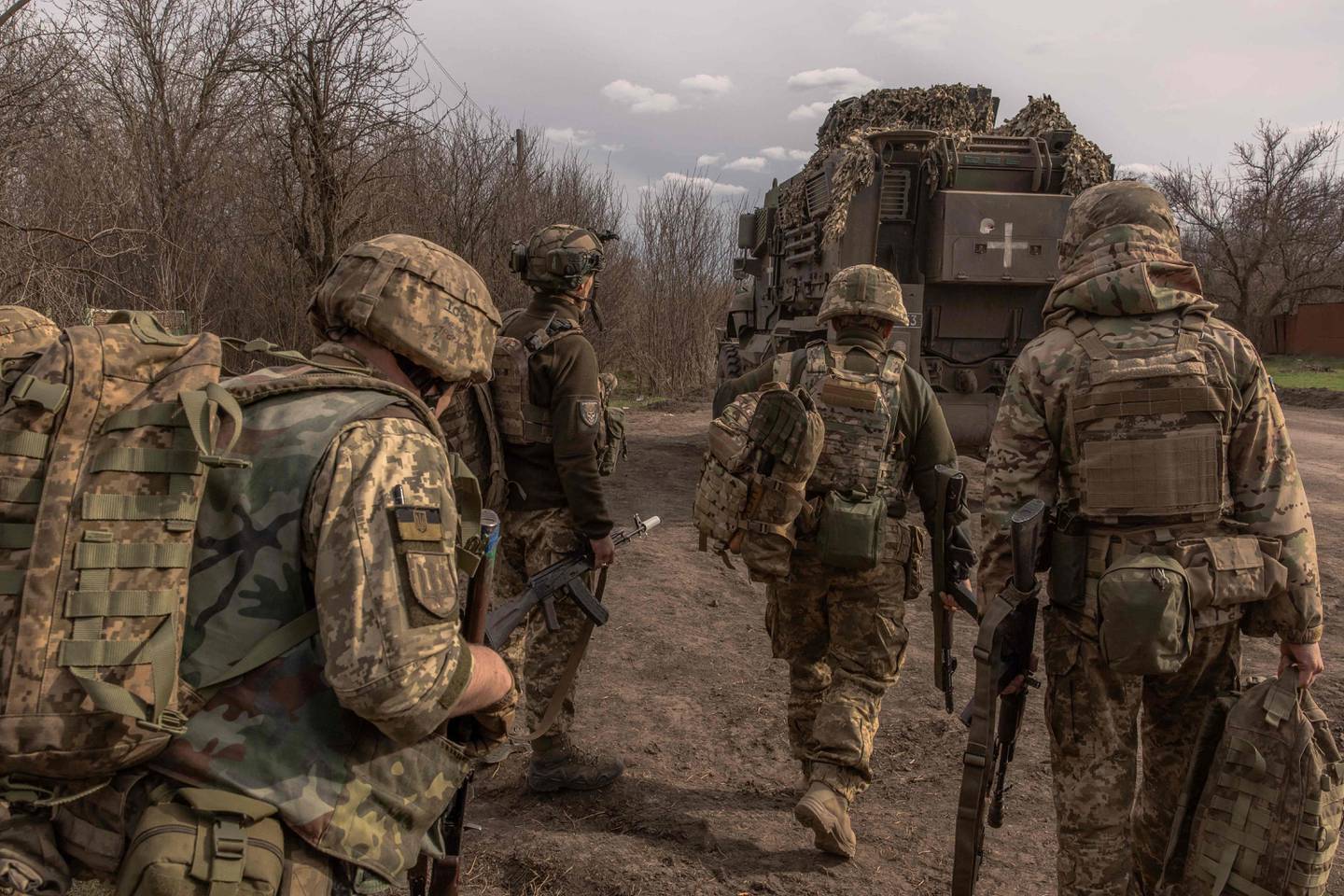 Ukrainian infantry soldiers of the 23rd Mechanized Brigade walk to board an armored fighting vehicle MaxxPro to head toward the frontline in the Avdiivka direction, in the Donetsk region, on April 3, 2024, amid the Russian invasion of Ukraine. (Photo by Roman PILIPEY / AFP)