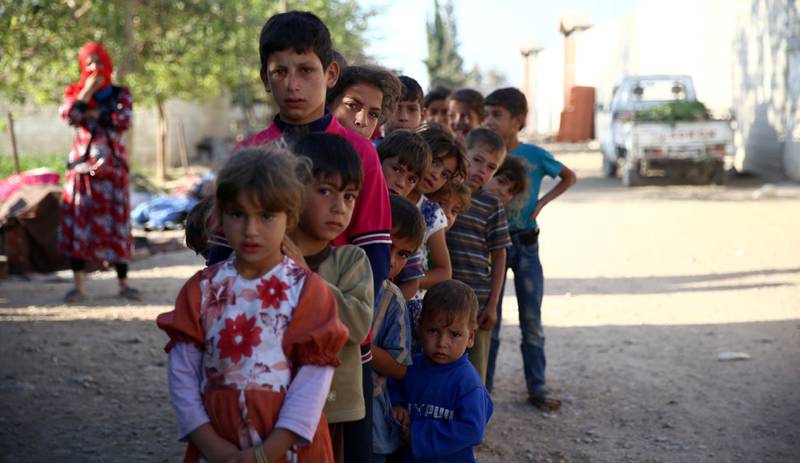 Hjelp: Syriske barn venter i kø på å få nødhjelp i Ghouta, øst for Damaskus, sist uke. 