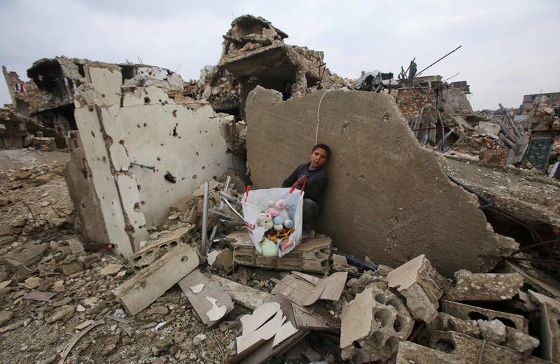 ALEPPO: En syrisk gutt sitter ting han fant i ruinene i nabolaget al-Arkoub i Aleppo. Med sterk russisk militærhjelp har det syriske regimet tatt kontroll over byen. FOTO: YOUSSEF KARWASHAN/NTB SCANPIX
